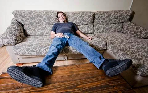 Tired man on sofa like a couch potato Stock Photos