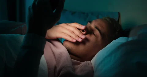 Tired man using mobile phone late night in bed Stock Footage 145290372