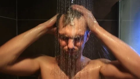 Tired man washes in the shower. He did not get enough sleep Stock Footage 76495832