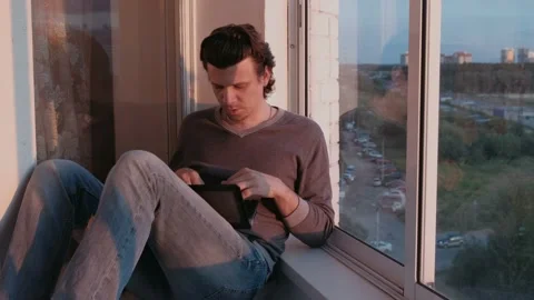 Tired man working on laptop and falls asleep sitting on balcony with city view Video stock 102449888