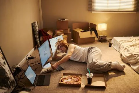 Tired Man Working on Multiple Computer Screens on Floor in New Home Stock Photos