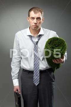 Tired manager holding briefcase and artificial grass Stock Photos