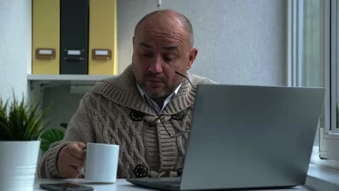 Tired middle aged man in eyewear working with computer sitting at home or in Stock-Footage 164975562