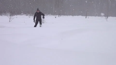 Tired middle aged man walks in snow shoes in forest covered in deep snow Stock Footage 231252559
