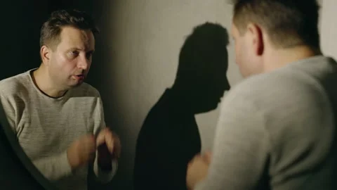 Tired middle-aged man washing his face in front of a mirror, illuminated by a Stock Footage 293485093