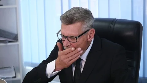 Tired old businessman working with a computer in a modern office Stock Footage 82635244