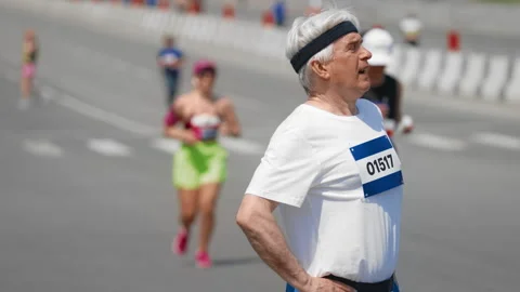 Tired old man run marathon. Senior exhausted runner take break. Elder sportsman. Stock Footage 308167647