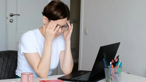 Tired overworked lady has a headache, migraine using computer working from home. Stock Footage 156602002