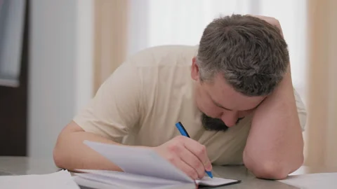 Tired overworked man falling asleep while writing at desk Stock Footage 340926737