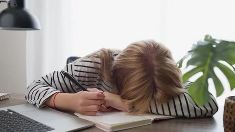 Tired overworked student napping on her desk while writing in a notebook, t.. Stock Footage 344844133