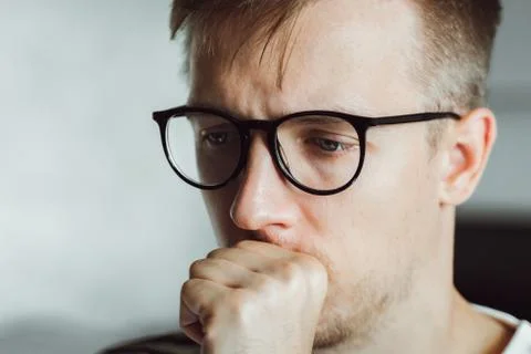 Tired pensive man deeply thinking at home. Winter depression. Seasonal affect Stock Photos
