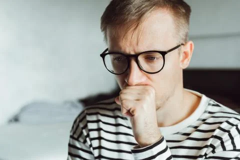 Tired pensive man deeply thinking at home. Winter depression. Seasonal affect Stock Photos
