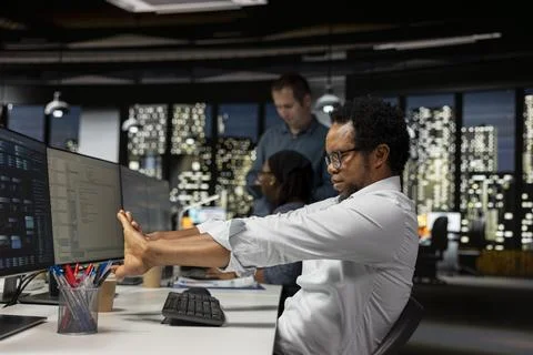 Tired programmer stretching joints in AI startup office, taking break Stock Photos
