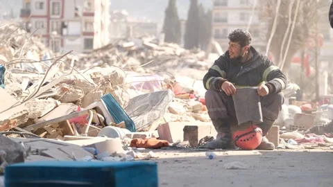 Tired Rescue Worker Watching Search Efforts by Rubble, February 8, 2023, Hatay, Video stock 336521970