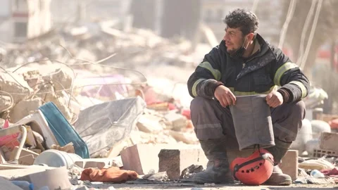 Tired Rescue Worker Watching Search Efforts by Rubble, February 8, 2023, Hatay, Video stock 336521971