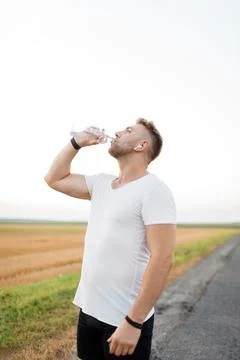 Tired runner drinking water Stock Photos