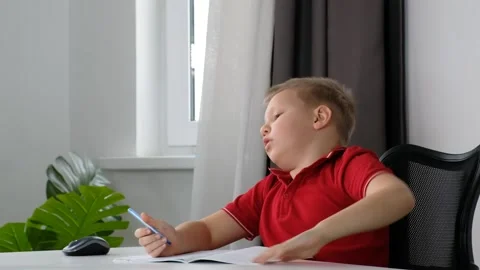 Tired school boy child doing his homework at home and feeling tired, sleepy and Stock Footage 172293333