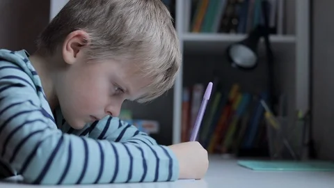 Tired schoolboy doing homework at home Stock Footage 102551750