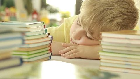   Tired schoolboy sleeping in classroom at school. Elementary school student.  Video stock 114503194