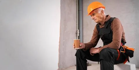 Tired Senior Construction Worker Having Coffee Break at Building Site After.. Stock Photos