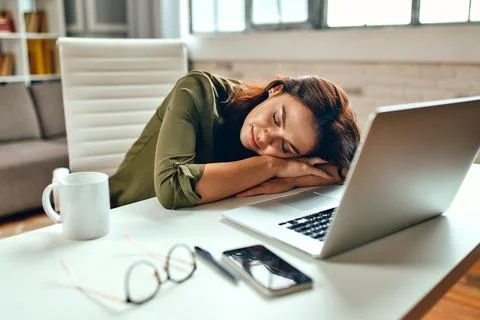 Tired sleepy business woman in stress fell asleep at the laptop while sitting Stock Photos