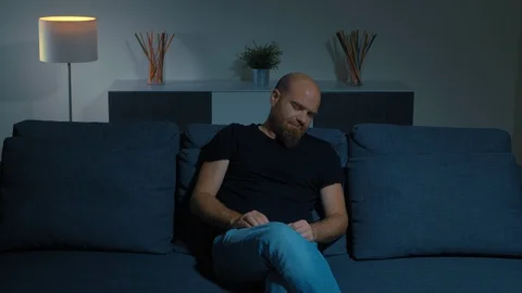 Tired sleepy man sitting on sofa,falling lying.tiredness, fatigue, sleep Stock Footage 104879649