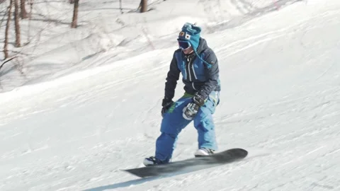 A tired snowboarder rides down a slope, falls on the snow and falls asleep Stock-Footage 221581600