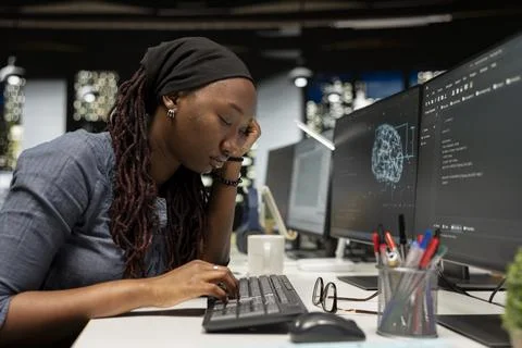 Tired software developer falling asleep on desk in AI startup office 库存照片