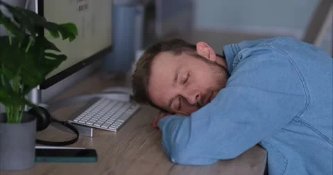 Tired software developer trying to sleep near computer at working place, 4k Stock Footage 220835299
