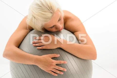 Tired sportive woman resting on fitness ball Stock Photos