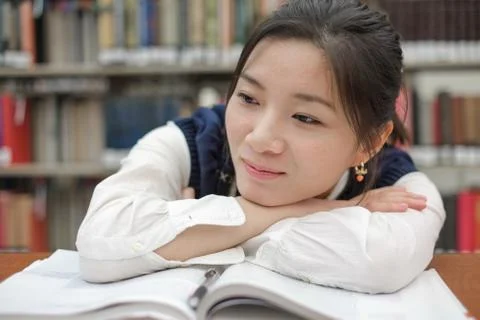 Tired student doing homework in library Stock Photos