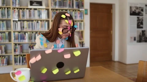 Tired student writing term paper surrounded by sticky notes and endless study ta Stock Footage 341657173