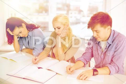 Tired students with notebooks at school Stock Photos