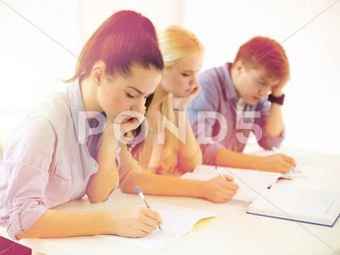 Tired students with notebooks at school Stock Photos