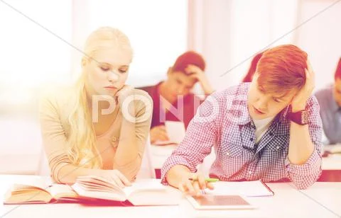 Tired students with tablet pc, books and notebooks Stock Photos