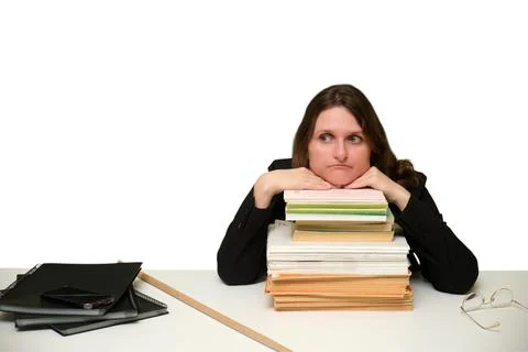 Tired teacher resting chin on stack of books at school desk. Thoughtful woman Stock Photos