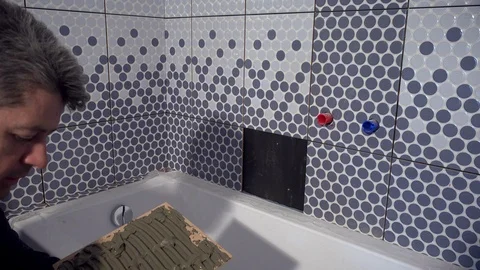 Tired tiler worker man install last tile in bathroom Stock Footage 107121813