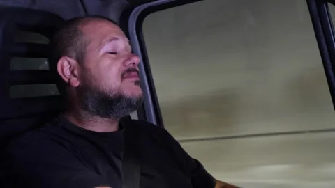 Tired truck driver yawns while driving through a tunnel at night Stock Footage 318582407