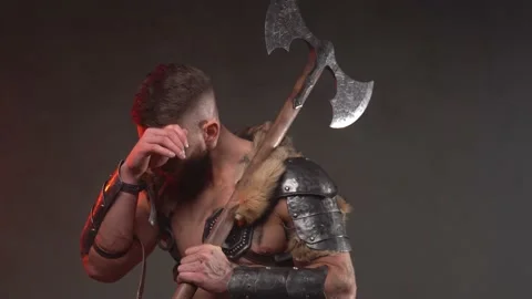 Tired viking warrior posing in dark background with naked torso and axe Stock Footage 146455562