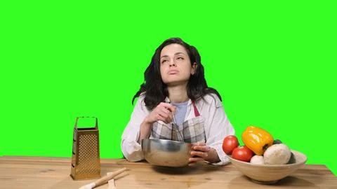 Tired woman beating while using silver bowl and whisk on the chroma key Stock Photos