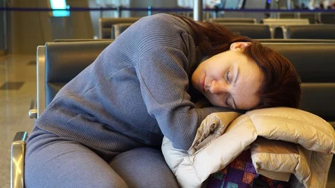 A tired woman is dozing while sitting in a chair while waiting for boarding a Video stock 128961869