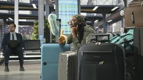 Tired woman eats banana in bus terminal during long distance journey Stock Photos