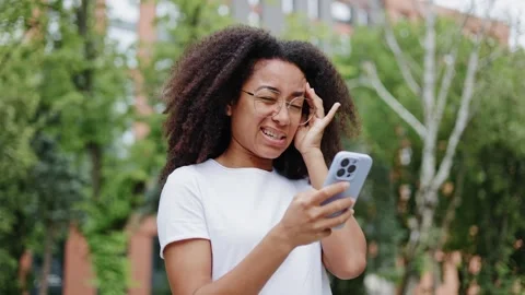 Tired woman massaging temples while browsing websited on smartphone outdoors Stock-Footage 280467331