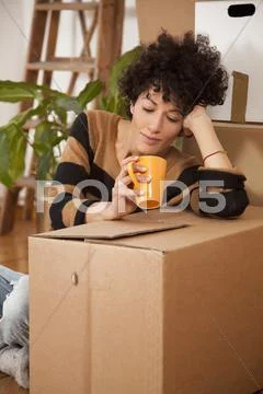 A tired woman taking a coffee break while moving house Stock Photos