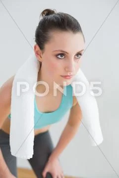Tired woman with towel around neck at fitness studio Stock Photos