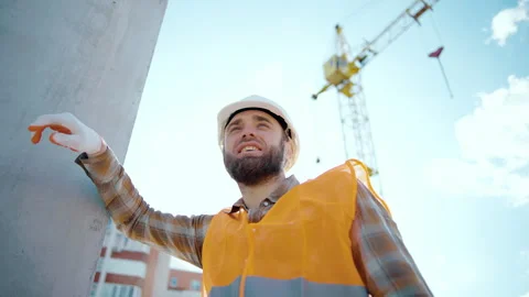 A tired worker at a construction site rests his hand on the wall after hard work Video stock 241171668