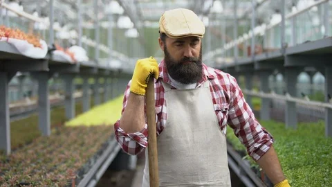 Tired worker looking seriously at camera in greenhouse exhausted by low-paid job Video stock 118936181