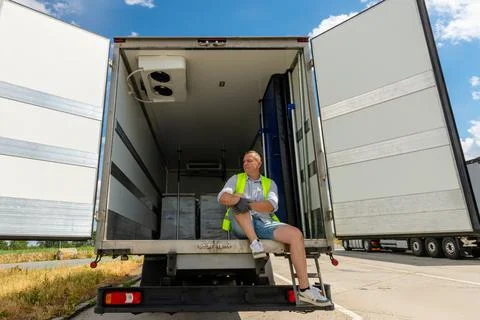 Tired worker resting inside an empty box truck Stock Photos