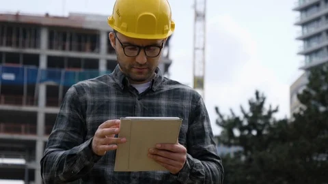A tired worker with tablet at a construction site. 스톡 동영상 119674202