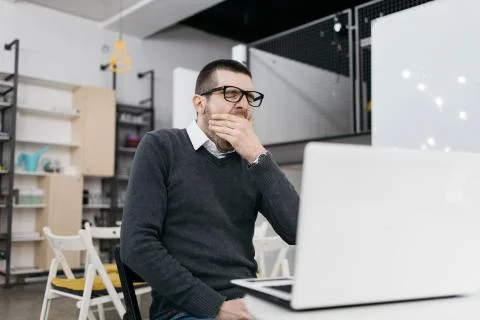 Tired worker yawn while sitting in office Stock Photos